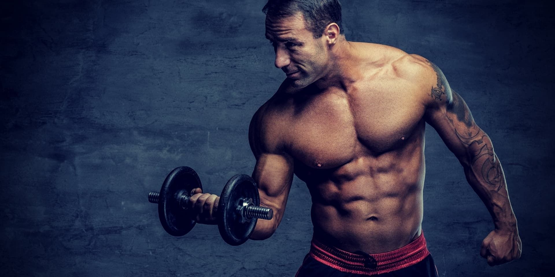 Building Muscle After 40 shirtless middle age man holds dumbbell