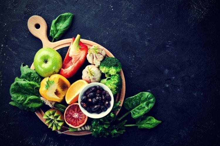 Fruits and vegetables that contain vitamin C. Orange, lemon, apple, roses, garlic, broccoli, apple, kiwi, spinach. Top view.