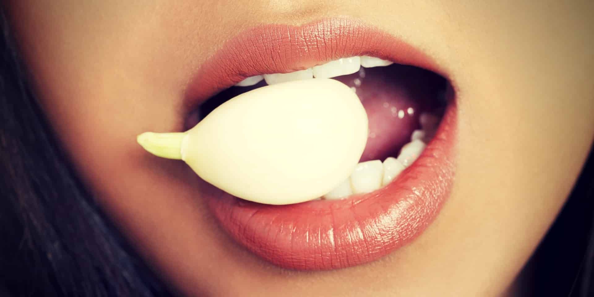 Garlic Benefits for Sex young beautiful woman eating garlic
